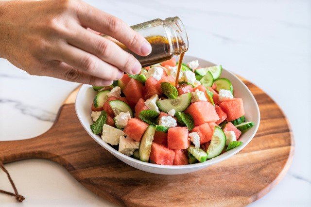 Pouring Balsamic Dressing on Watermelon Salad