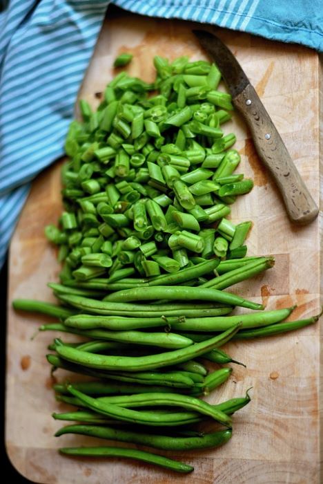 chopped green beans on a wooden chopping board